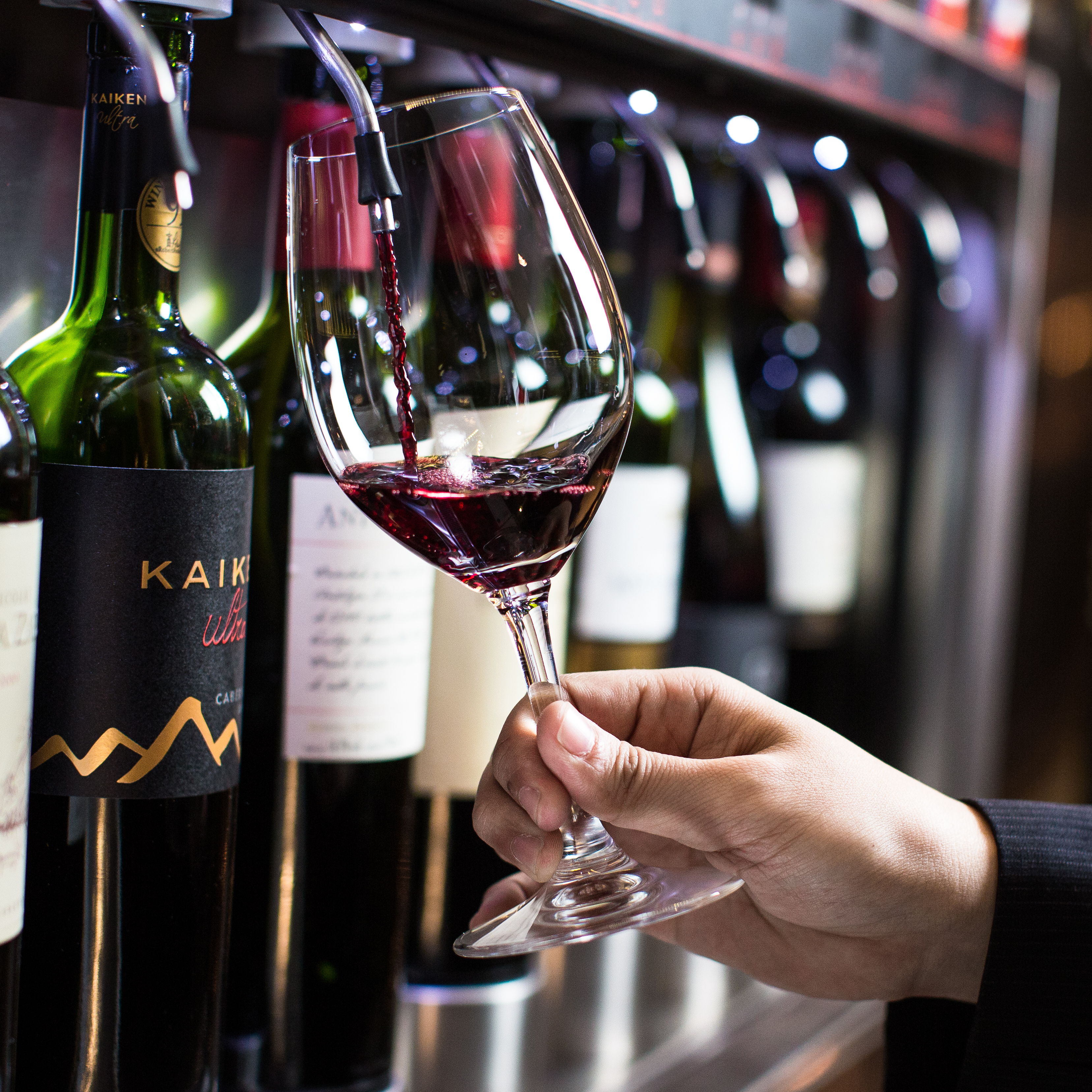 Sommelier apresentando um rótulo junto às wine machines do Bardega